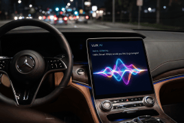 Nighttime interior of a Mercedes-Benz with a steering wheel and a center touchscreen displaying a colorful waveform graphic.