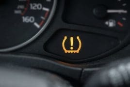Tire pressure warning light illuminated on the car dashboard, indicating low tire pressure