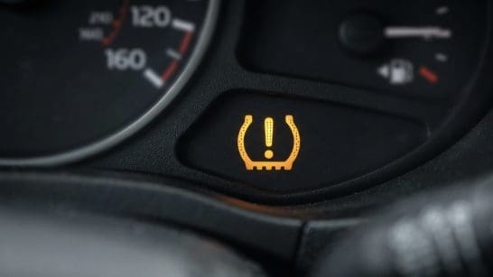 Tire pressure warning light illuminated on the car dashboard, indicating low tire pressure