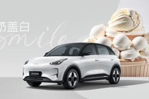 White electric SUV in front of a giant ice cream dessert backdrop with the word 'smile' in cursive text.