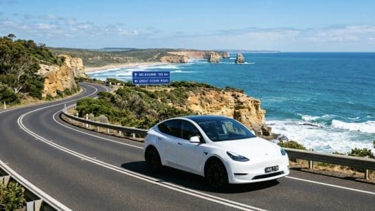 Img3169 | ยางรถยนต์ ราคาอัปเดต 2026 ครบทุกยี่ห้อ รวมยาง Ev | Autotirechecking White electric car on a winding coastal road with rocky cliffs and the blue ocean; road signs indicate Melbourne 150 km and the Great Ocean Road.