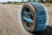 Tire on a highway with a futuristic blue holographic readout showing tread depth 6.8 mm and diagnostic data from the tire sidewall (Continental).