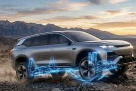 Silver SUV on rocky desert terrain with a glowing blue holographic drivetrain visualization beneath the wheels.